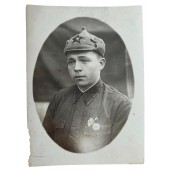 Puna-armeijan sotilas, jolla on virkamerkit ja Budjonovkan hattu
