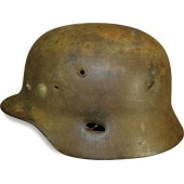 ET 64 marked M 35 war time reissued camouflaged steel helmet with fragmentation damage