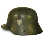 M 16 Deutscher Helm mit einem Abzeichen. Kriegszeit neu aufgelegt
